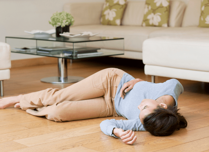 mulher caída no chão desmaiada